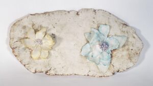 Two flowers on a wall in a courtyard